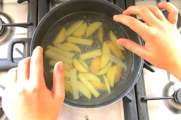 Des morceaux de pommes de terres dans de l’eau bouillante