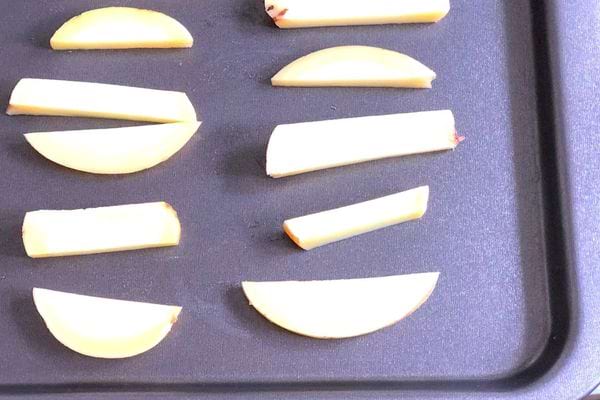 Des morceaux de pommes de terres sur une plaque de pâtisserie 