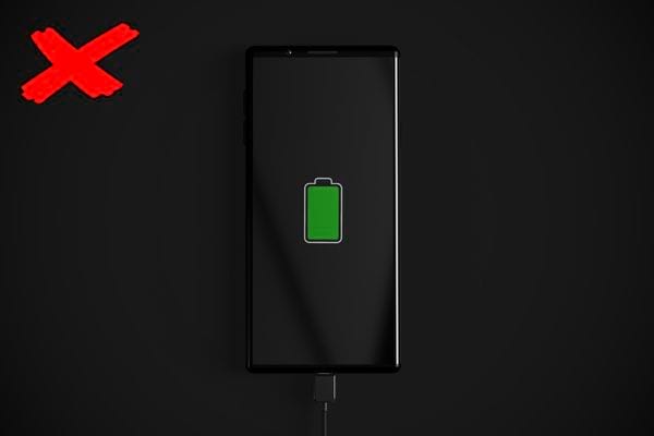 Un téléphone qui charge sur un fond noir avec une croix rouge dans l'angle à gauche