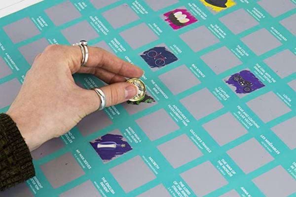 Une personne grattant une affiche 100 livres à gratter pour ne jamais s'ennuyer