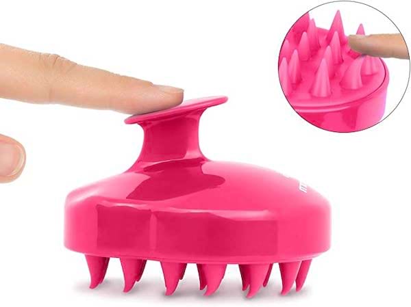 Une brosse de tête rose pour masser le cuir chevelu