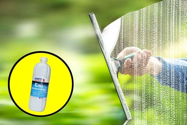 Une personne nettoyant ses vitres avec de l'eau déminéralisée 