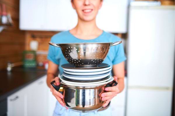 Une femme tenant des casseroles