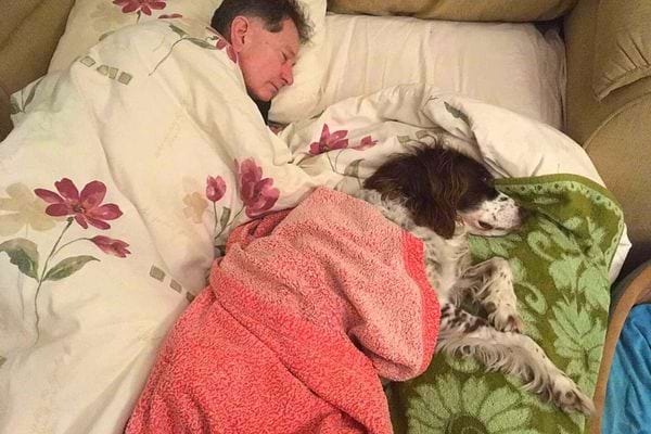 Un homme qui dort avec son chien 