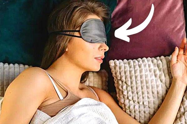 Une femme qui dort avec un masque gris sur ses yeux 