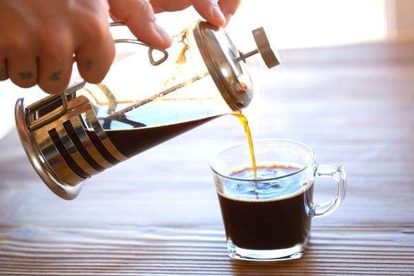 Une personne se servant du café