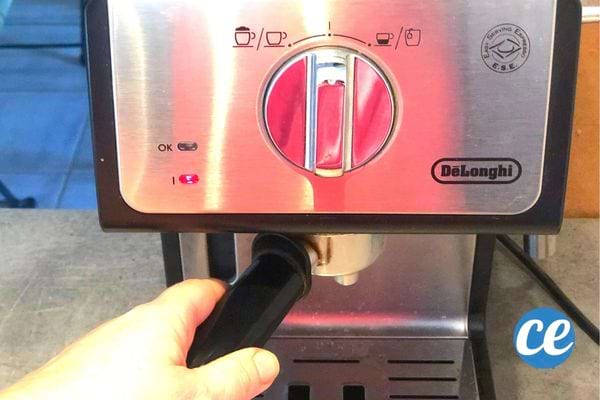 Une personne retirant le porte-filtre d'une machine à café