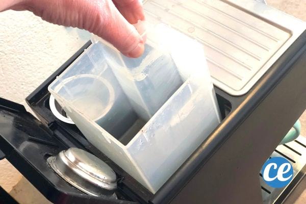 Une personne retirant le réservoir d'une machine à café