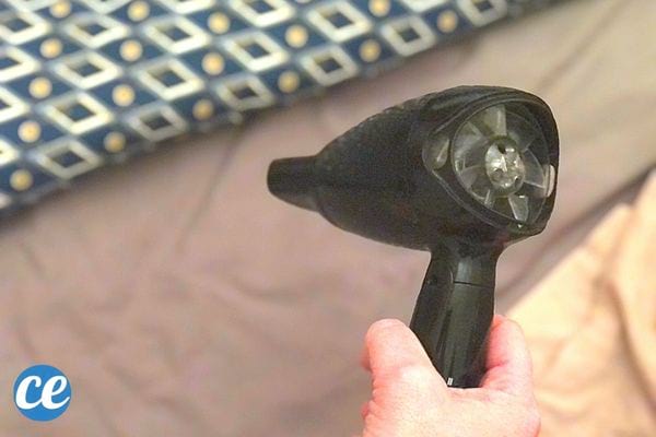 Une personne tenant un sèche-cheveux