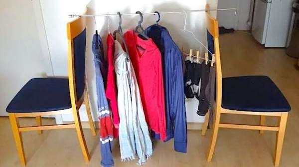 du linge sur des cintres sèche sur une tringle posé entre deux chaises