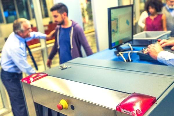 Une personne se faisant contrôler dans le service sécurité de l'aéroport