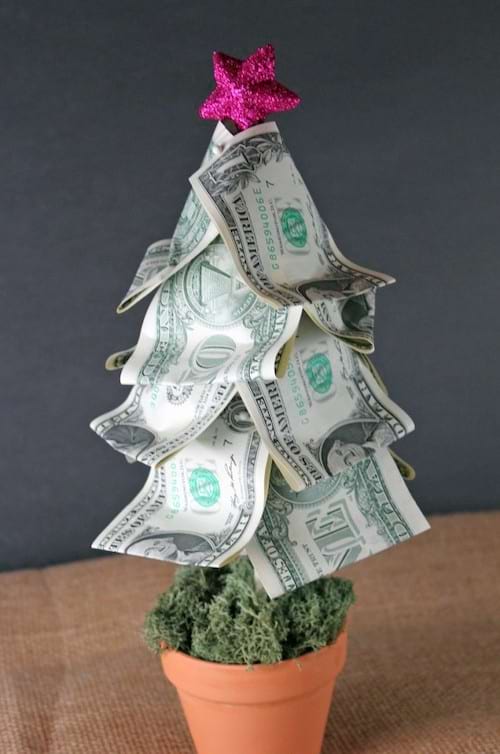 Un arbre de Noël fait avec des dollars avec une petite étoile violette au dessus 