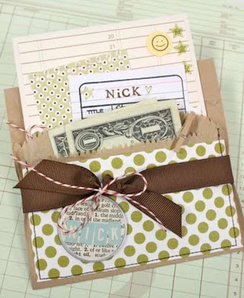 Une pochette en papier avec un ruban marron avec des feuilles à l'intérieur dont des billets