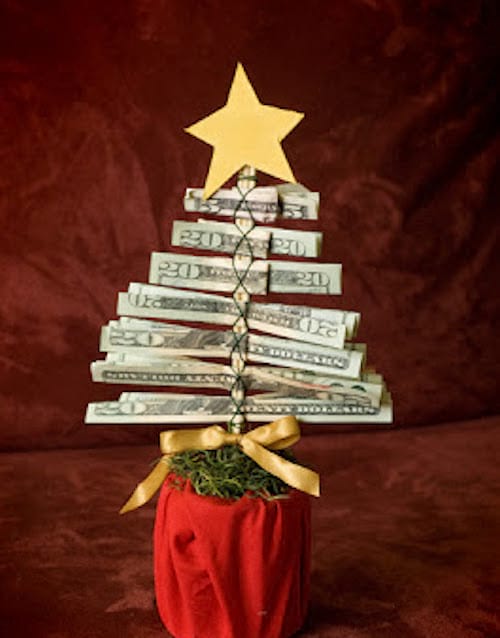 Un petit sapin de Noël fait maison avec des billets Américains avec une petite étoile au dessus