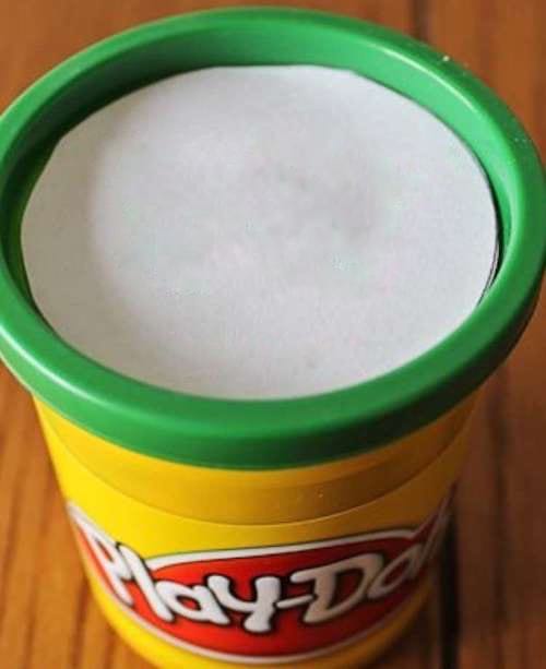 Un boîte de pâte à modeler jaune et verte de la marque "play-doh"