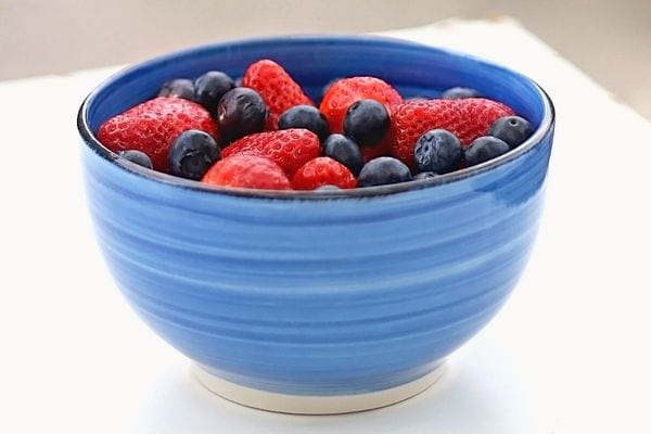 Un bol rempli de fraises et de myrtilles