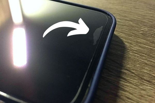 Une partie de verre trempé avec une bulle sur l'écran du smartphone