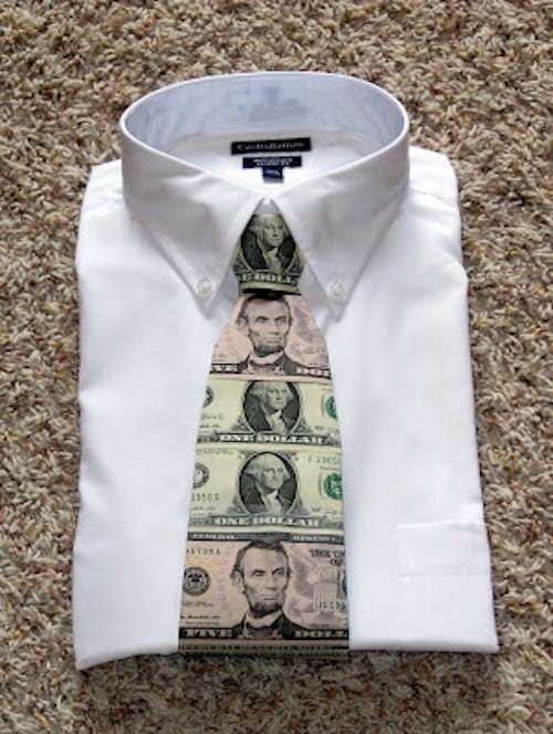 Une cravate faites avec des dollars mise sur une chemise blanche 