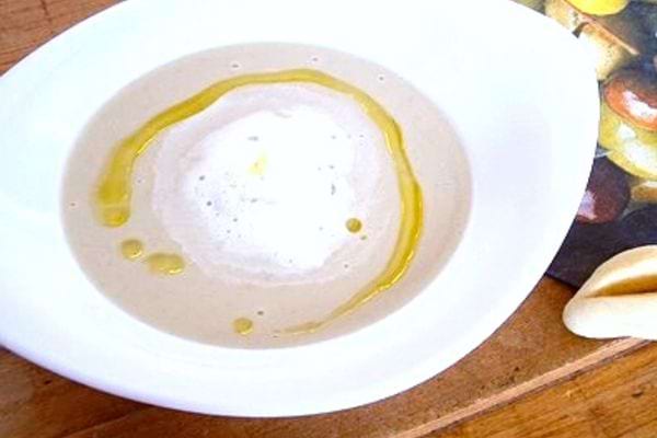 Crema di carciofi con olio al tartufo su piatto bianco
