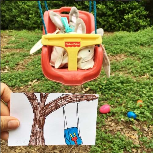 Une balançoire avec une peluche à l'intérieur et une personne qui tient un dessin à côté