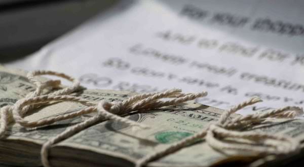 Une liasse de dollars qui est ficelé sur une feuille 