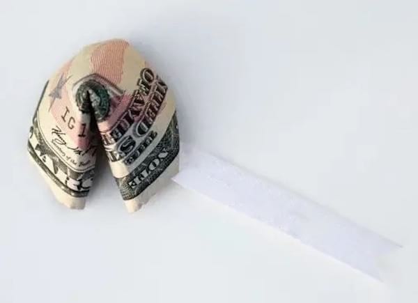 Un dollar qui est plié avec une petite étiquette blanche pour pouvoir l'offrir 