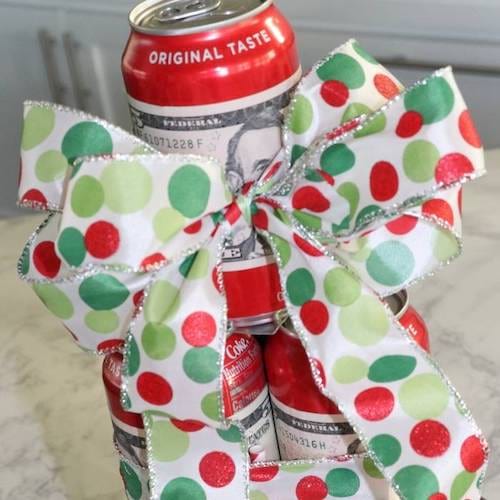 Des cannettes de coca qui sont enveloppées de dollars avec des rubans 