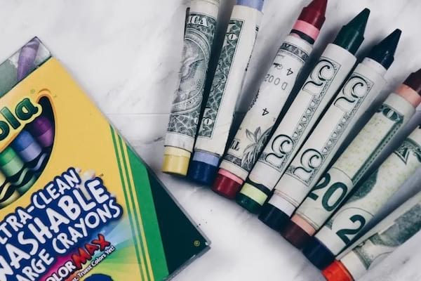 Des dollars qui entourent plusieurs crayons 