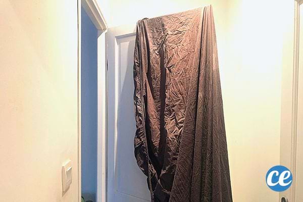 Un long drap qui est étendue sur une porte blanche 