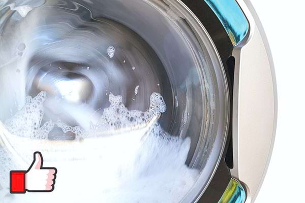 Du savon dans un tambour de machine à laver en marche 
