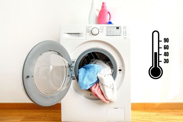 Une machine à laver ouverte avec des linges qui y sont à l'intérieur