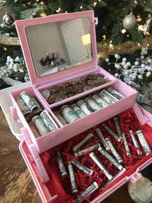 Un organisateur de maquillage rose avec de la monnaie et des dollars à l'intérieur 