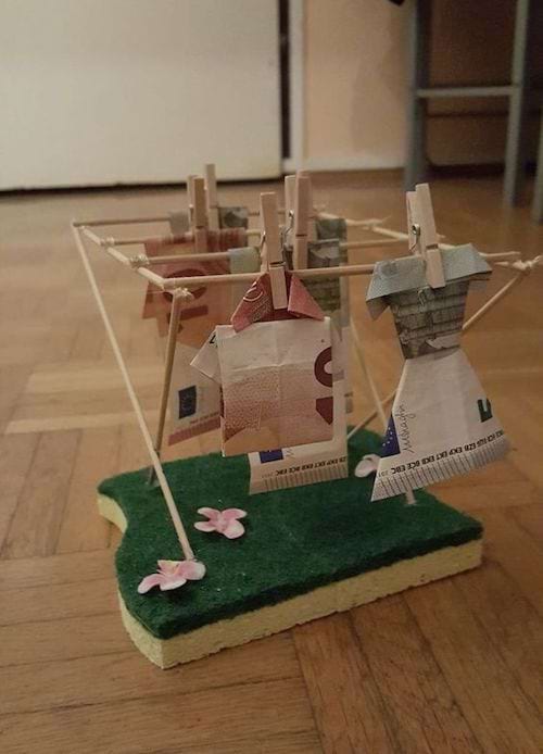 Plusieurs billets en origami qui sèche sur un séchoir en bois fait maison 