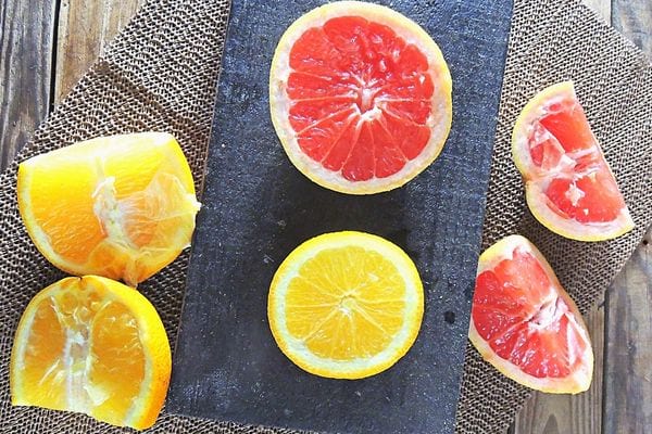 Plusieurs morceaux de pamplemousse avec des morceaux d'orange découpés