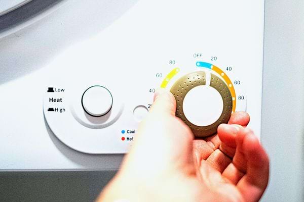 Une personne programmant son sèche-linge 