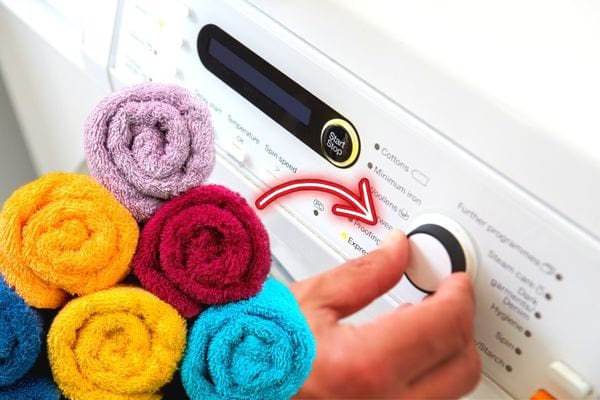 Plusieurs serviettes de différentes couleurs avec une machine à laver