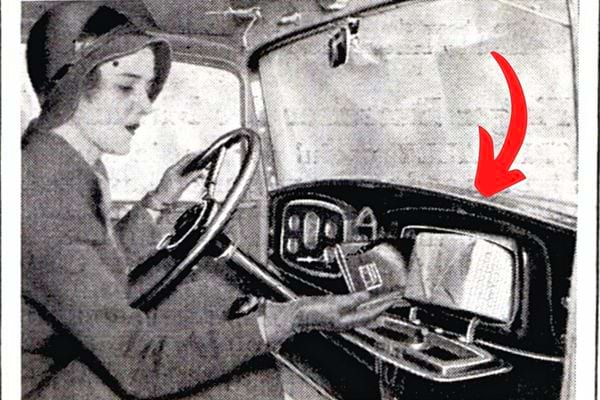 Eine Frau in einem Auto hält ein Produkt in Schwarz-Weiß in Richtung Handschuhfach