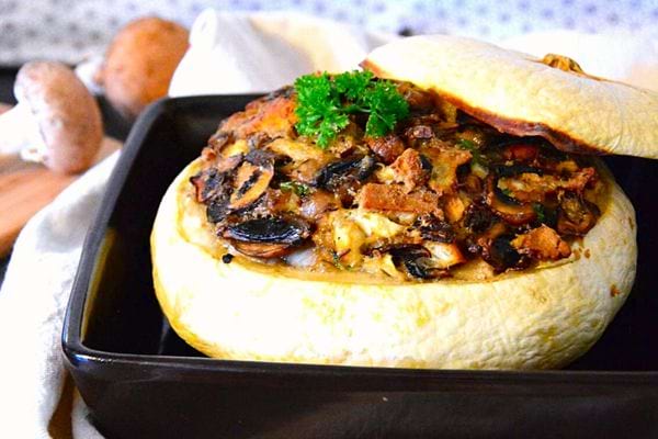 Un plat pâtisson farci aux champignons et fromage bleu dans une verrine noire