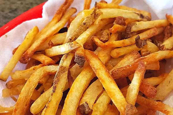 Plusieurs frites sur un plateau rouge avec de l'essuie-tout