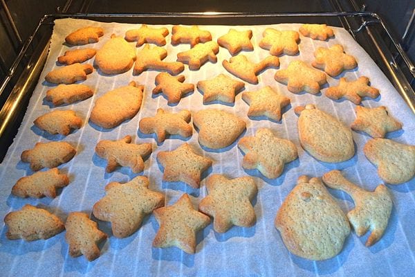 Plusieurs sablés qui sont sur une feuille de cuisson dans un four