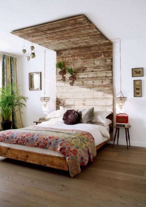 Un lit avec des planches en bois au plafond qui servent de tête de lit