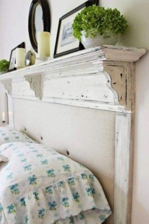 Un ancien cadre de cheminée repeint qui sert de tête de lit avec de la décoration au-dessus