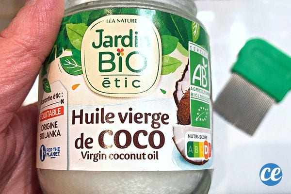 Une personne tenant un bocal d'huile de coco dans sa main