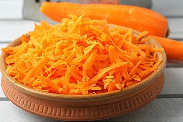 De la carotte râpée dans un récipient marron 