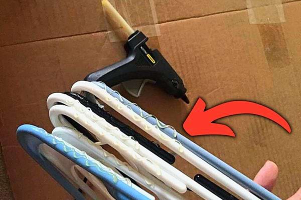 De la colle mise sur plusieurs cintres avec un pistolet à colle à proximité