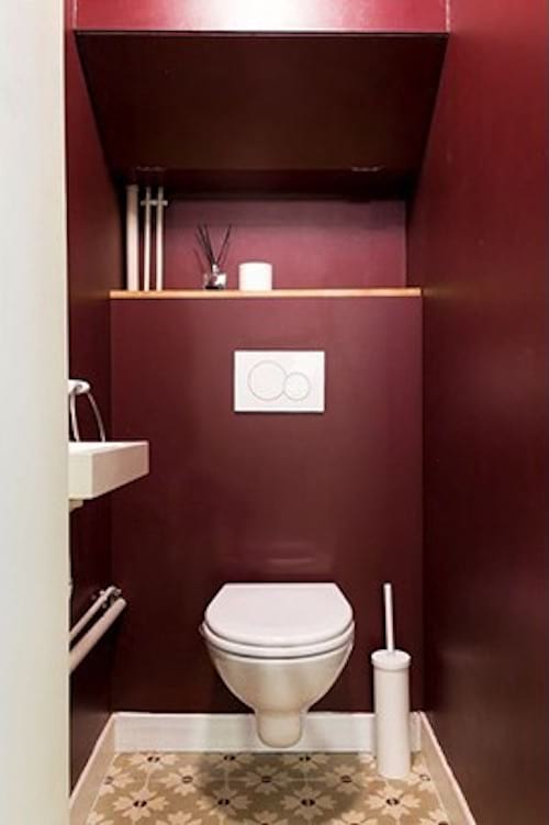 Toilets with mauve colored walls 