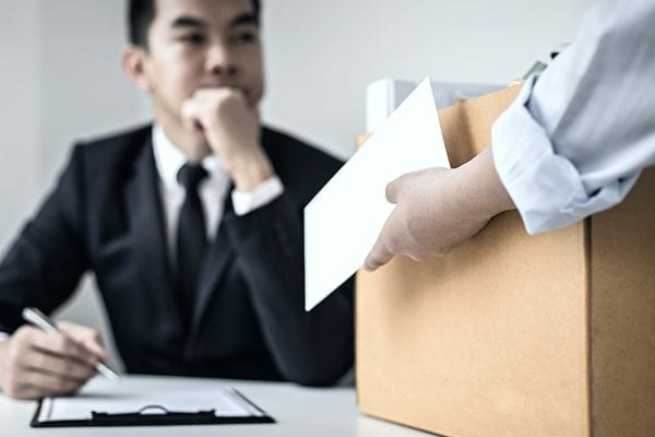 Un homme asiatique septique devant un autre tenant un carton 