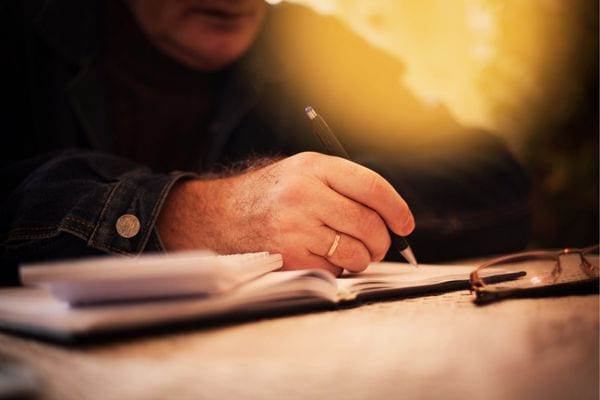 Un homme fiancé qui tient un stylo en main 