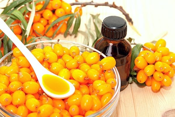 De l'huile de pépin d'argousier avec le fruit tout autour