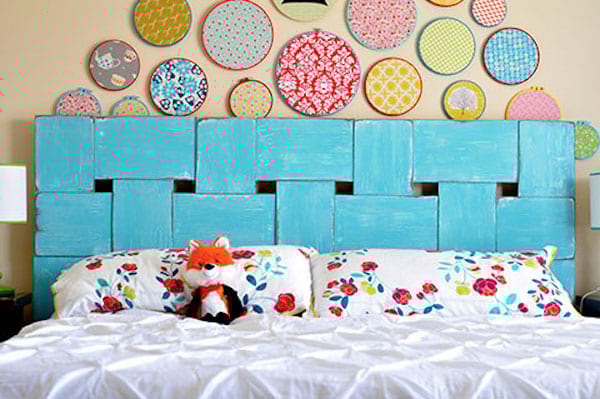 Un lit blanc avec une peluche en renard avec des longues planches bleues et des ronds au mur